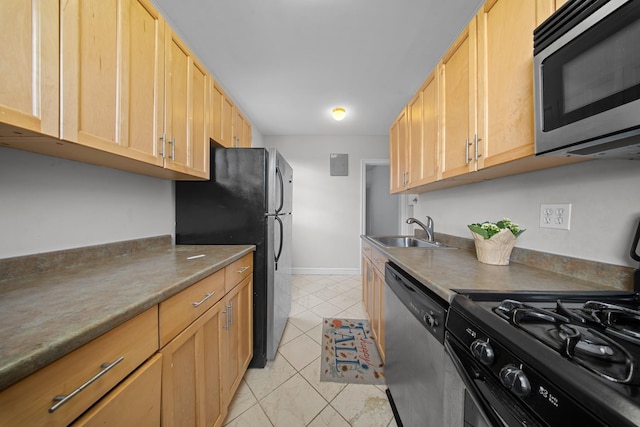 kitchen with light tile patterned floors, light brown cabinets, a sink, baseboards, and appliances with stainless steel finishes