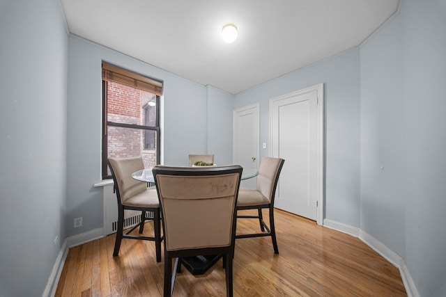 dining area with light wood-style flooring and baseboards