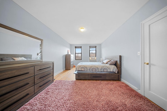 bedroom with light wood finished floors and baseboards