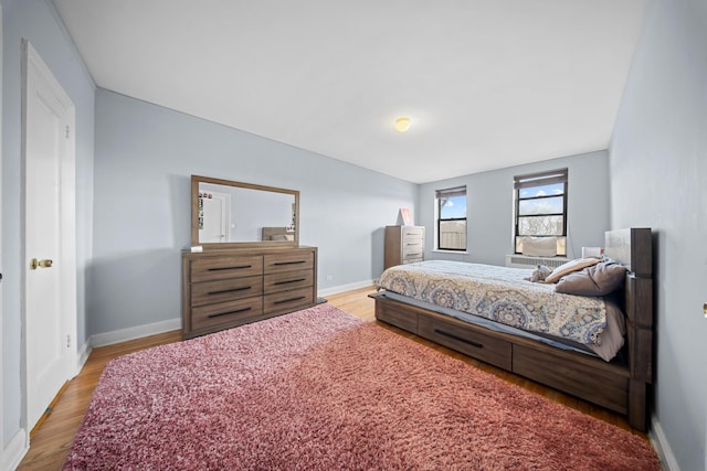 bedroom with light wood-style flooring and baseboards