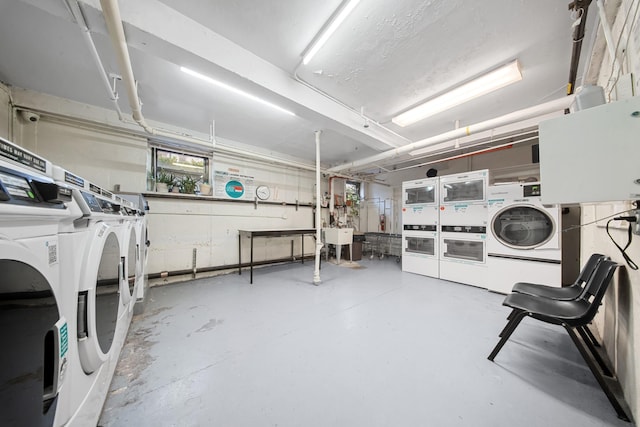 common laundry area featuring stacked washer and dryer, a sink, and washing machine and clothes dryer