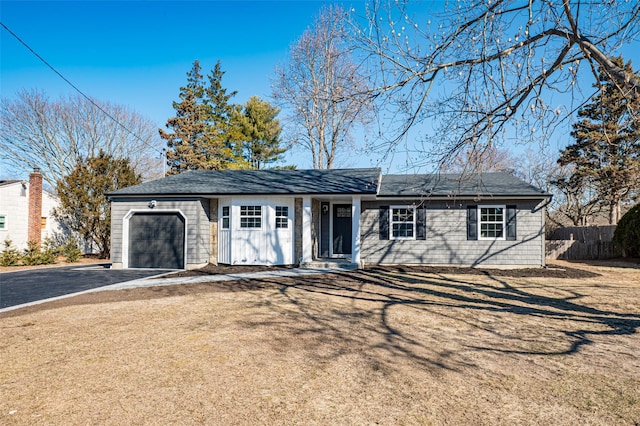 single story home featuring driveway, an attached garage, and fence