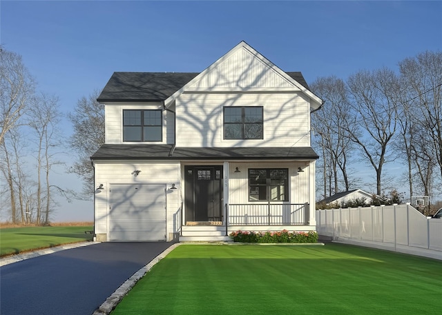 view of front of home featuring covered porch, fence, a garage, driveway, and a front lawn