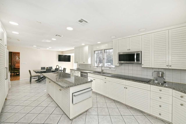 kitchen with light tile patterned floors, stainless steel appliances, a sink, and a warming drawer