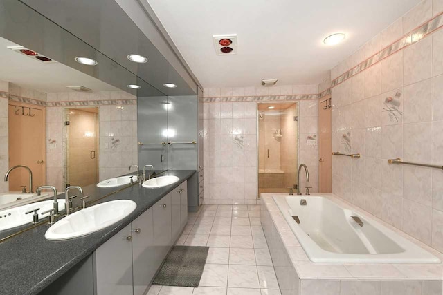 bathroom featuring a garden tub, a sink, and tile walls