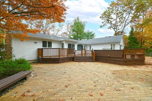 back of property featuring a patio and a wooden deck