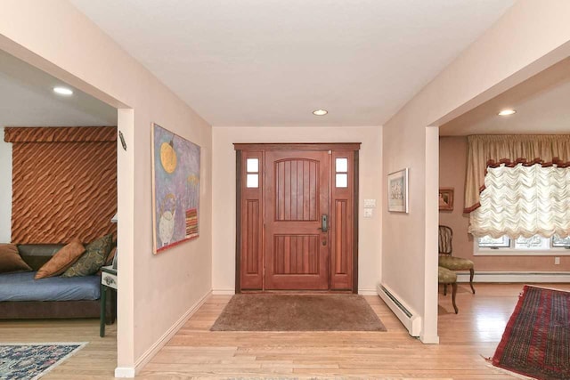 foyer entrance featuring light wood-style floors, baseboards, and baseboard heating