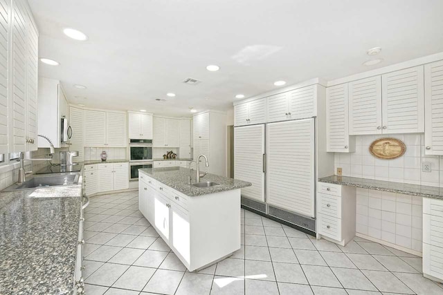 4 Hunting Hill Dr, Dix Hills, NY 11746 - kitchen with stainless steel appliances, recessed lighting, tasteful backsplash, light tile patterned flooring, and a center island with sink