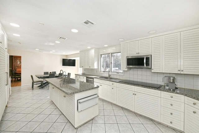 4 Hunting Hill Dr, Dix Hills, NY 11746 - kitchen featuring appliances with stainless steel finishes, a warming drawer, decorative backsplash, a kitchen island with sink, and recessed lighting