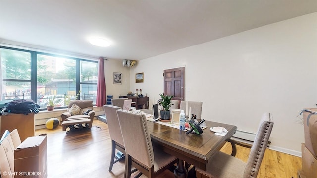 dining area featuring light wood finished floors and baseboards