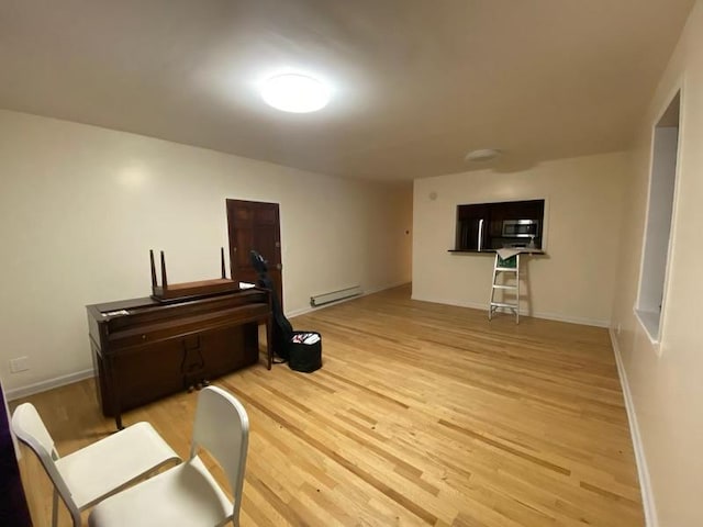 interior space featuring baseboards, baseboard heating, and wood finished floors