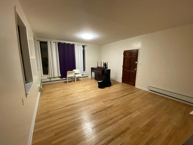 spare room with light wood-type flooring, baseboards, and baseboard heating