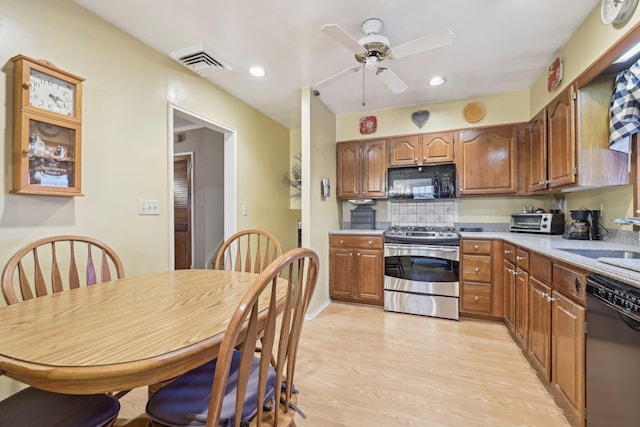 kitchen featuring light wood finished floors, stainless steel gas stove, a sink, black microwave, and dishwashing machine