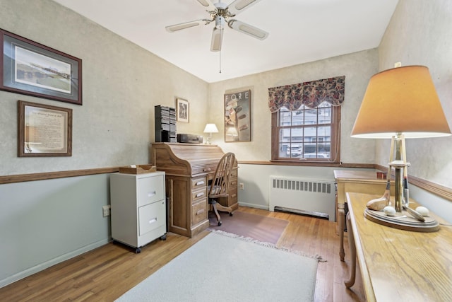 office area with baseboards, ceiling fan, hardwood / wood-style flooring, and radiator