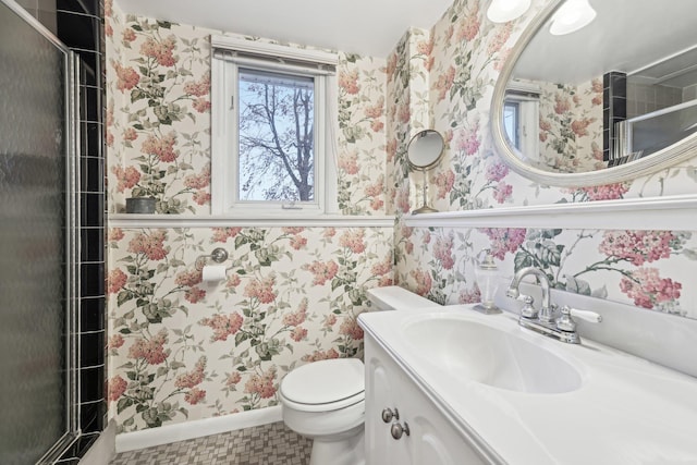 bathroom featuring vanity, toilet, and wallpapered walls