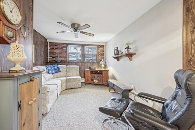 living area featuring a baseboard radiator, carpet floors, wood walls, a ceiling fan, and baseboard heating