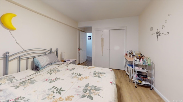 bedroom with a closet, baseboards, and wood finished floors