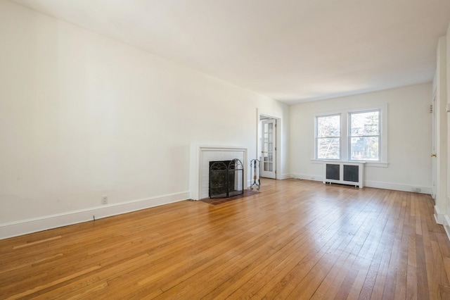 unfurnished living room featuring light wood-style flooring, a fireplace, and baseboards