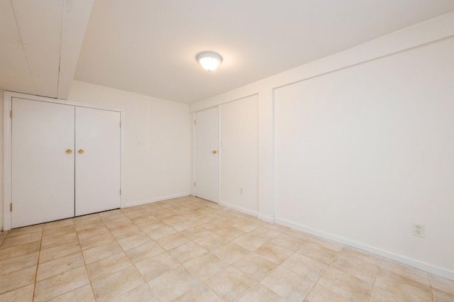 unfurnished room with light tile patterned floors and baseboards