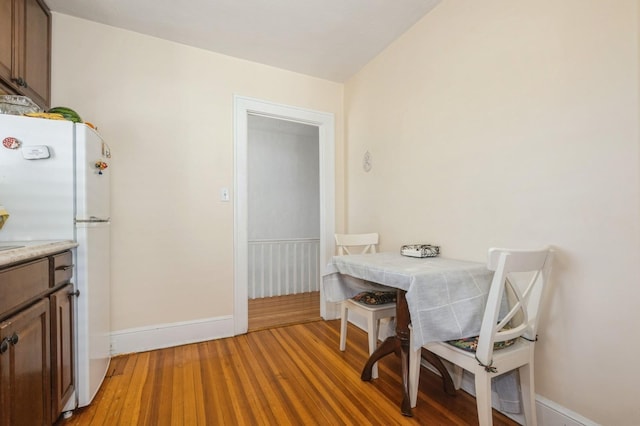 dining room with light wood-style flooring and baseboards