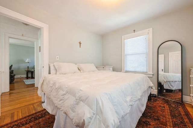 bedroom featuring baseboards and wood finished floors