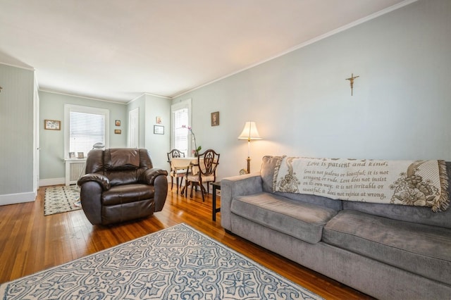 living room with radiator, crown molding, baseboards, and hardwood / wood-style floors