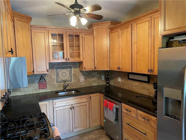 kitchen with tasteful backsplash, dark stone counters, stainless steel fridge with ice dispenser, ceiling fan, and a sink