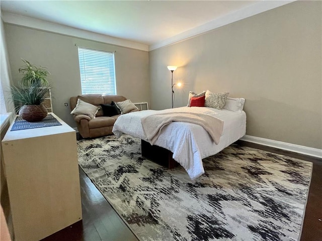 bedroom with ornamental molding, dark wood-type flooring, and baseboards