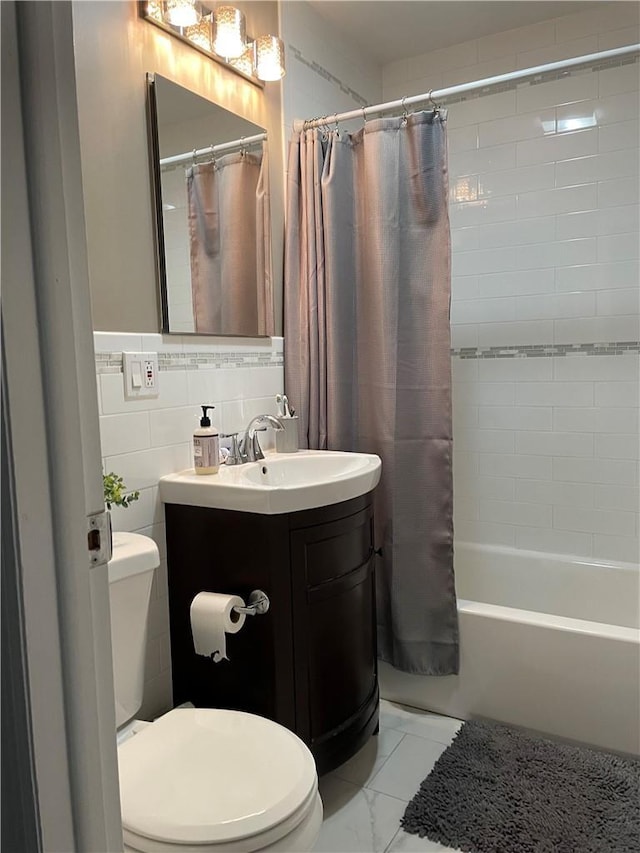 full bathroom featuring toilet, vanity, tile walls, marble finish floor, and shower / bath combo