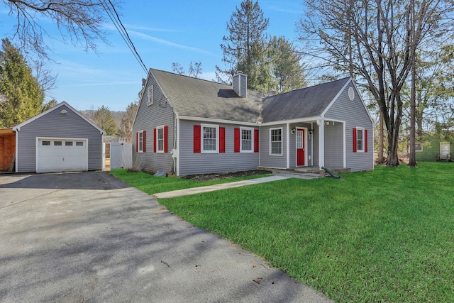 new england style home featuring an outbuilding, a front yard, driveway, a chimney, and a garage