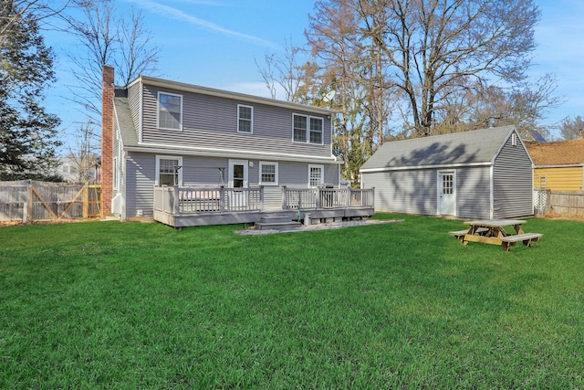 rear view of property featuring a wooden deck, a yard, a chimney, and a fenced backyard