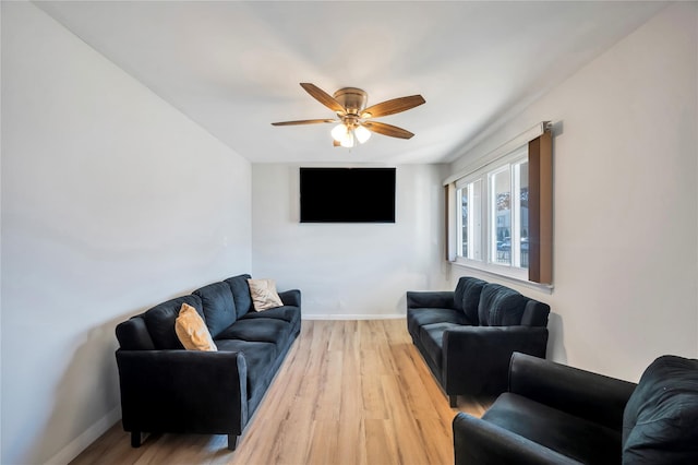 living room with baseboards, ceiling fan, and light wood finished floors