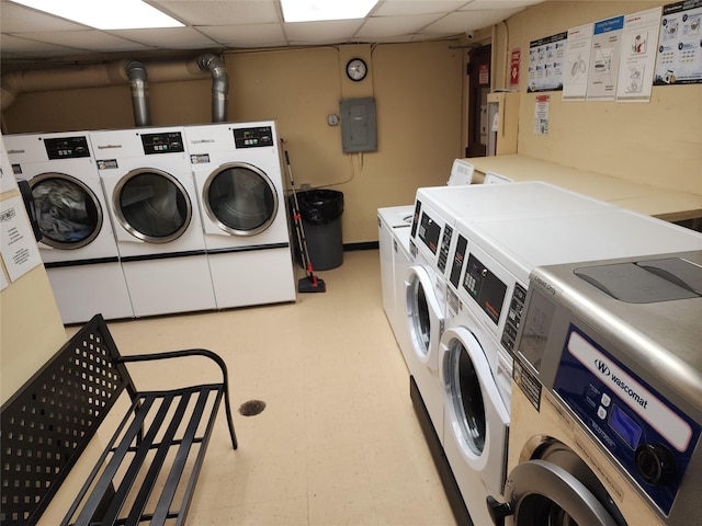 common laundry area with washing machine and dryer, electric panel, and light floors