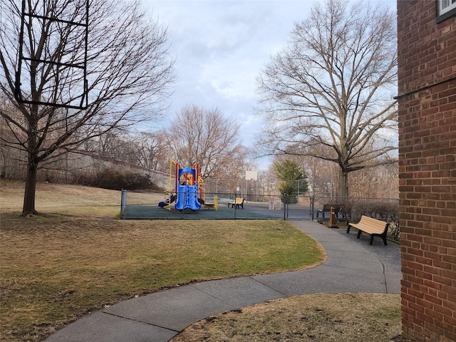 view of home's community featuring a lawn, a gate, fence, and playground community