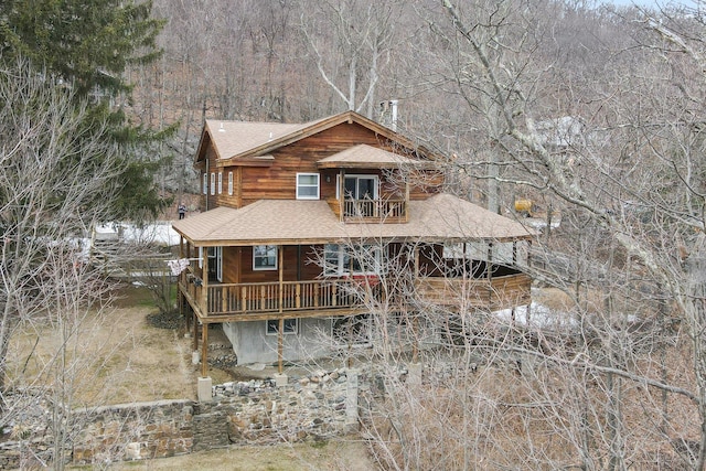 view of front facade featuring a balcony and a shingled roof