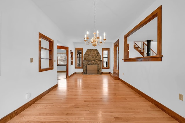 interior space with a chandelier, baseboards, a baseboard radiator, and light wood-style floors