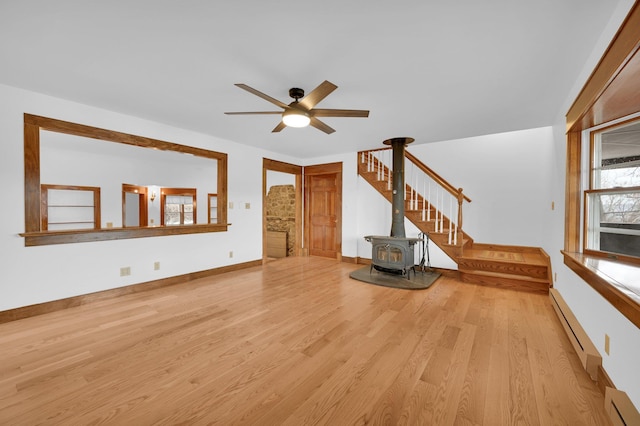 unfurnished living room featuring ceiling fan, baseboards, baseboard heating, and wood finished floors