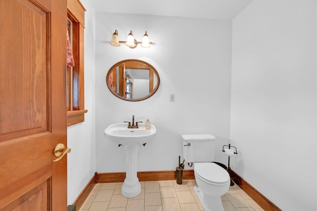 bathroom featuring toilet, baseboards, and tile patterned floors