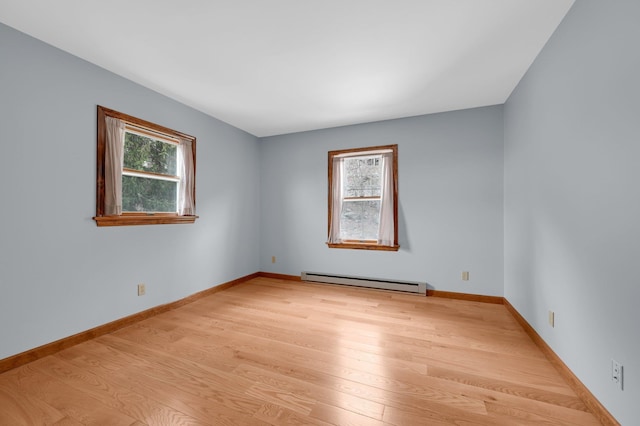 unfurnished room featuring a baseboard radiator, light wood-style flooring, and baseboards