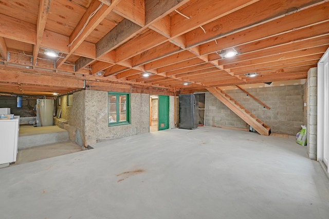 basement with stairs, gas water heater, and washer / dryer