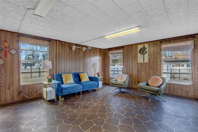 living area featuring stone floors and wood walls