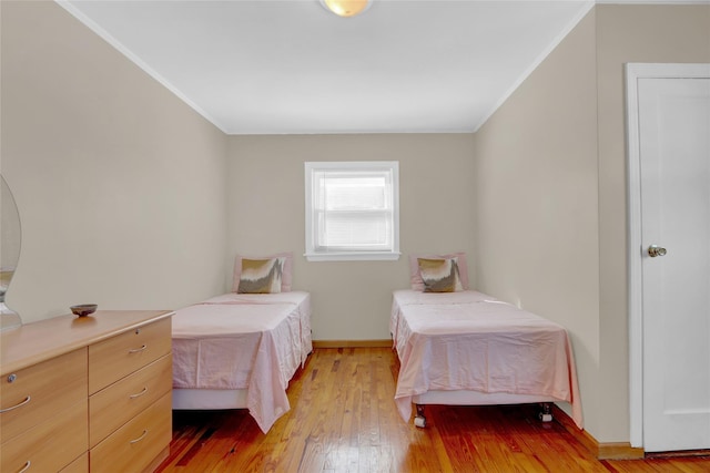 bedroom with ornamental molding and light wood-type flooring