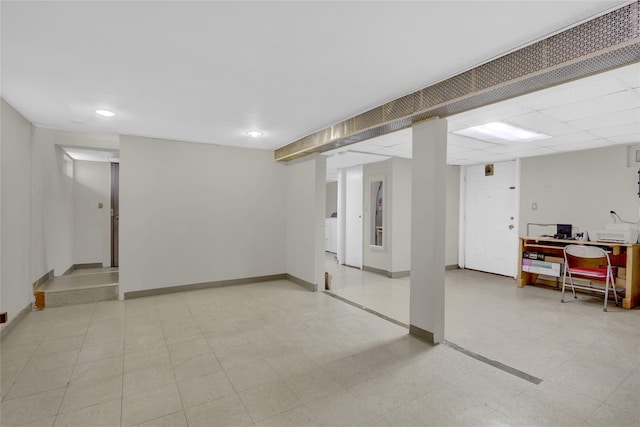 finished basement with light floors, baseboards, and washer / dryer