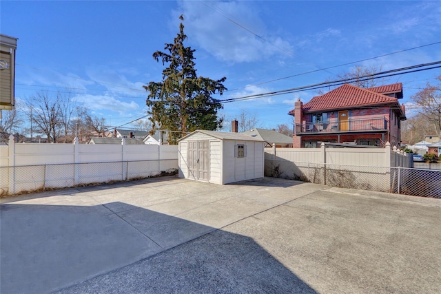 view of patio / terrace with a fenced backyard, an outdoor structure, and a storage shed