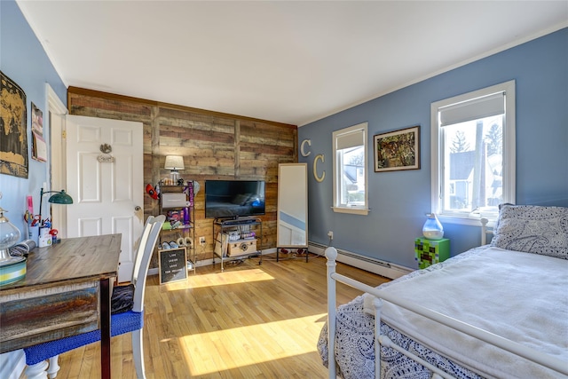 bedroom with a baseboard radiator and wood finished floors