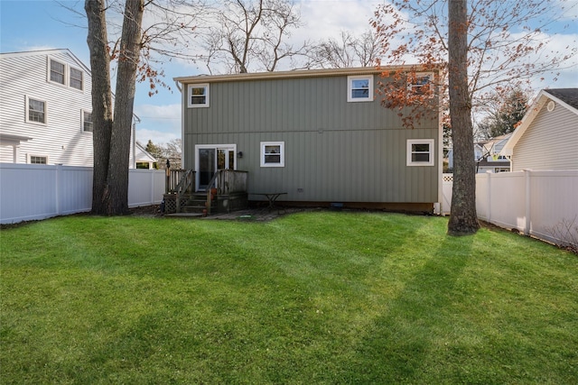 rear view of house with a yard and a fenced backyard