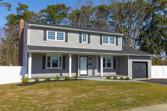 view of front of home featuring a chimney, covered porch, an attached garage, fence, and a front lawn