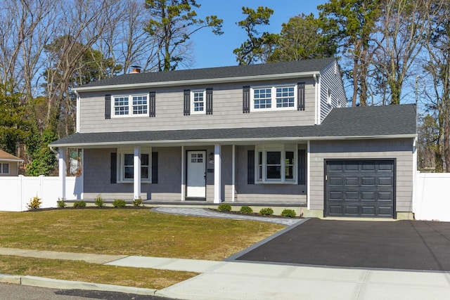 view of front of home with a garage, a front yard, roof with shingles, and fence