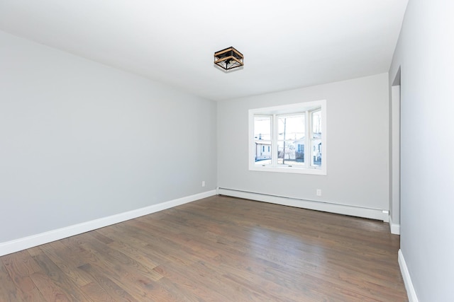 empty room with a baseboard radiator, baseboards, and dark wood-style flooring