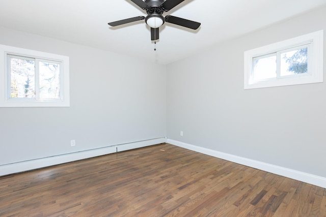 unfurnished room featuring a baseboard radiator, wood finished floors, a wealth of natural light, and baseboards